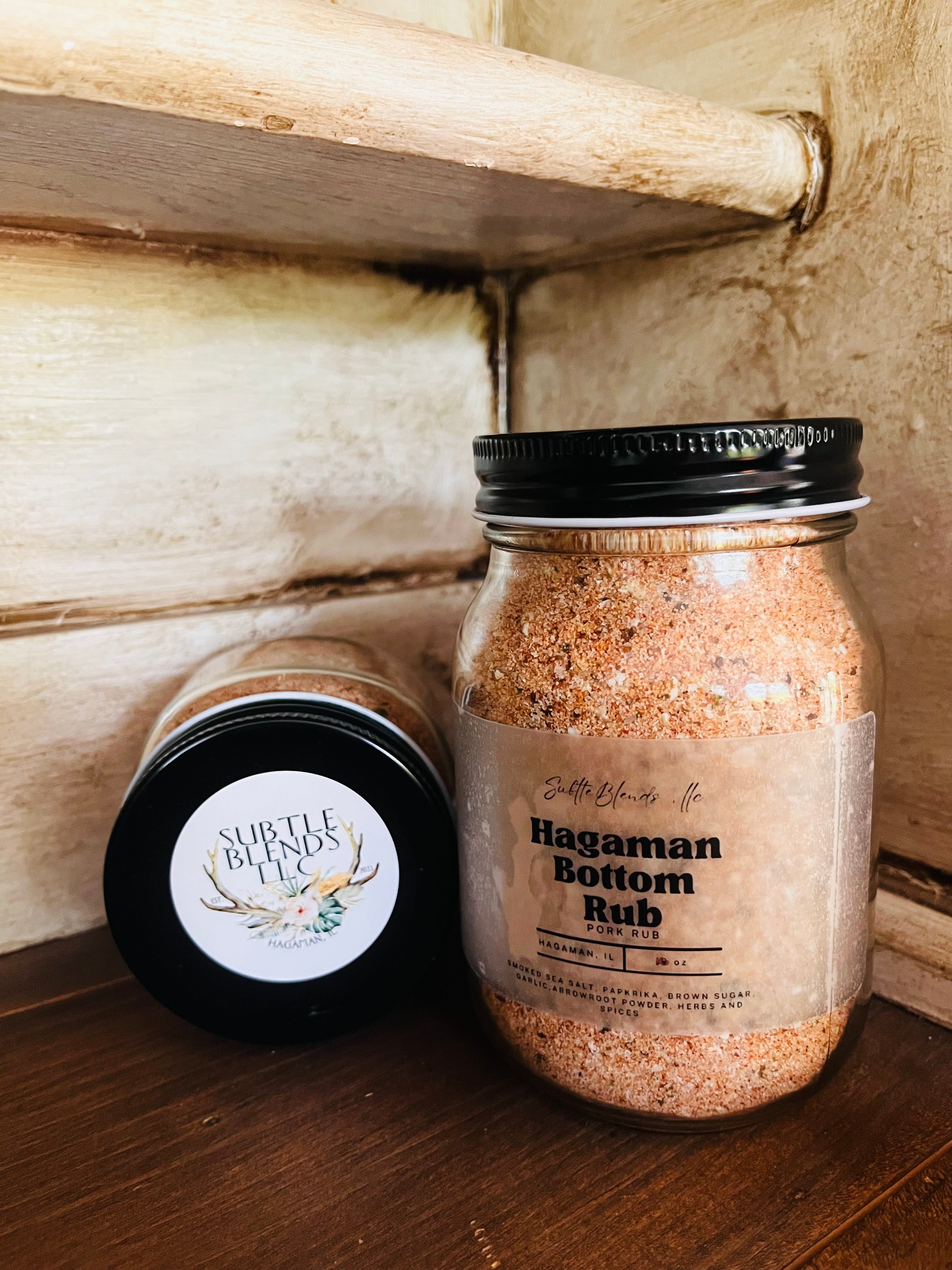 Two jars of Hagaman Bottom Rub on a wooden shelf.