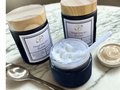 Jars of magnesium butter on a marble surface with a spoon and small dish.