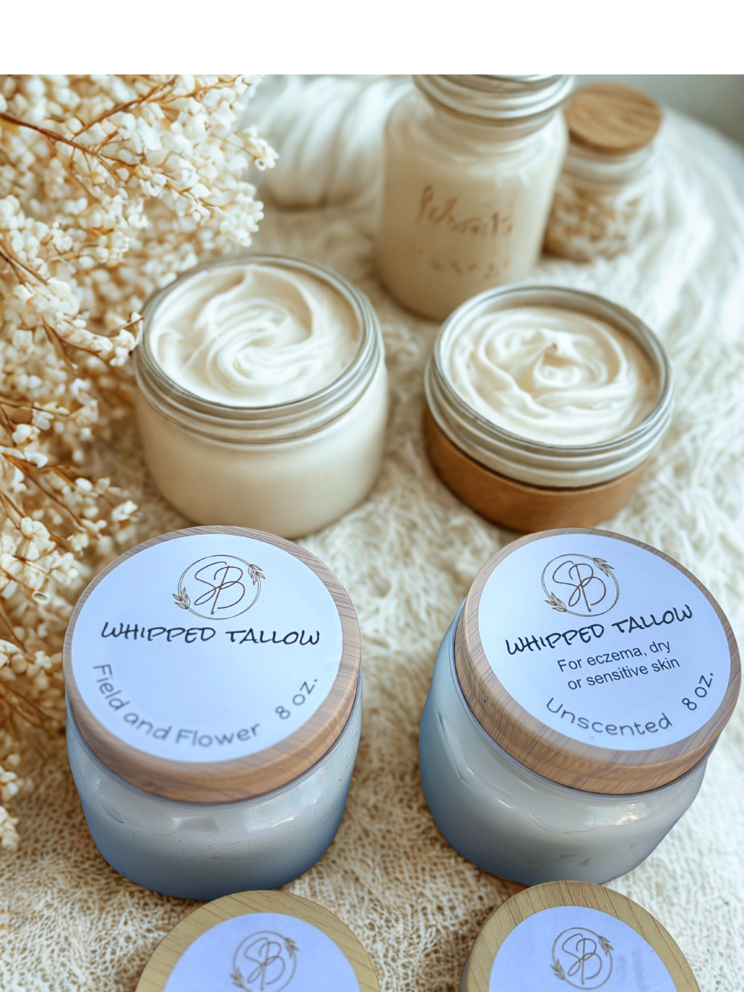 Jars of whipped tallow with visible branding on a textured surface.